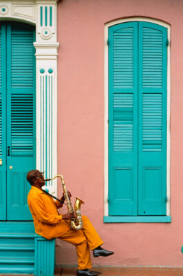 Man playing saxophone in front of house in New Orleans, Louisiana
