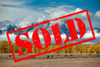 The Wyoming Teton mountains overlaid with a Sold sign.