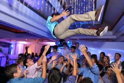 A bar mitzvah celebrant is thrown in the air at his party. Photo courtesy of Chad David Kraus (@chadkrausphoto, www.chadkraus.com)