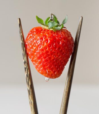 Oishii strawberry held by chopsticks. Photo: Oishii